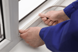 Installing window draught excluder.